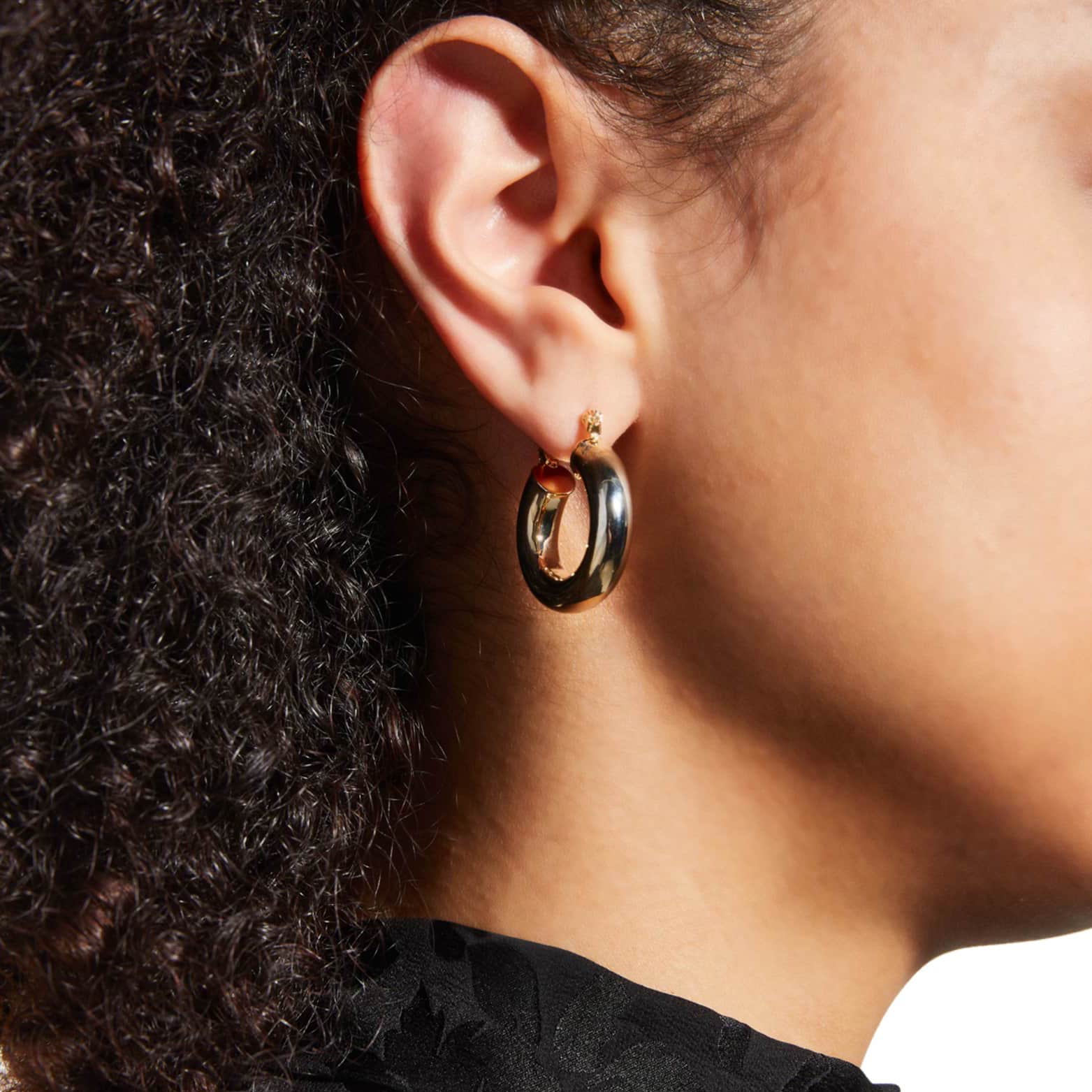 a pair of gold hoop earrings on a white background